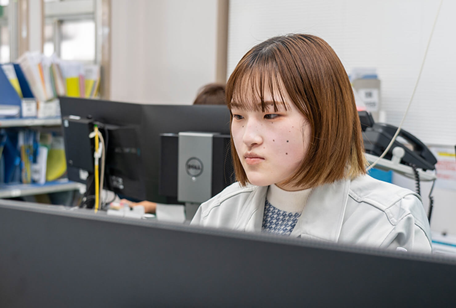 生産管理部:社内で女性社員がパソコンを前に仕事をする様子