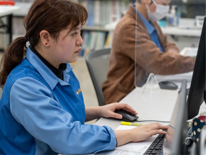 生産技術部:社内で女性社員がパソコンを前に仕事をする様子